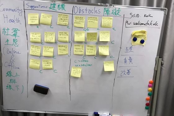 Whiteboard mit gelben Haftnotizen in Spalten für Vorschläge und Hindernisse