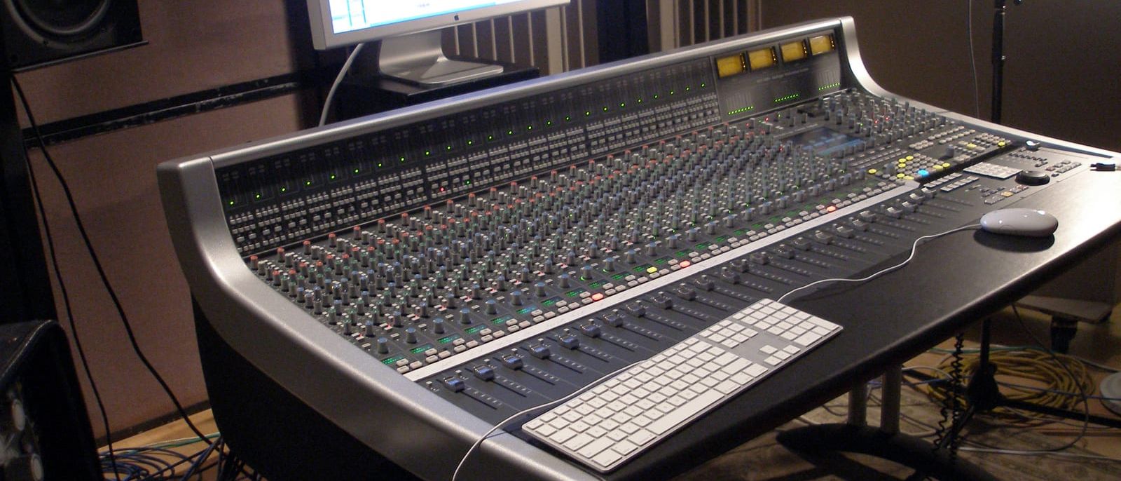 Großes Mischpult in einem Tonstudio mit Monitor, Lautsprechern und Mikrofonstativ
