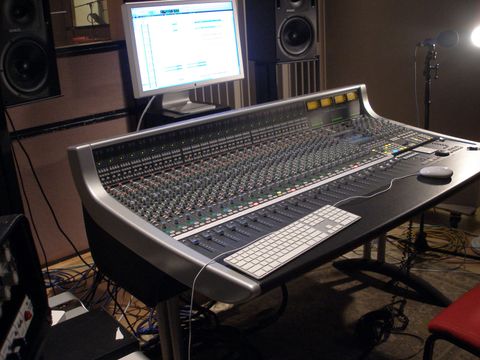 Großes Mischpult in einem Tonstudio mit Monitor, Lautsprechern und Mikrofonstativ