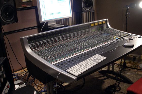 Großes Mischpult in einem Tonstudio mit Monitor, Lautsprechern und Mikrofonstativ